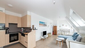 Un appartement moderne comprenant une cuisine, un coin repas et un salon.