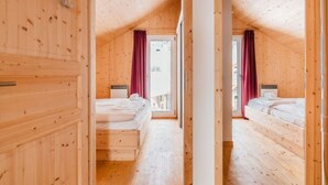 A wooden cabin with two bedrooms, each with a bed and a window. - Chalet Prinz Comfortable Holiday Residence (Murau)