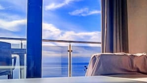 A room with a bed, a window with a view of the ocean, and a balcony railing. - Belvilla by OYO Apartamento 2habitaciones (Fuengirola)