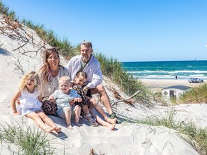 Une famille sur une plage de sable, avec vue sur l’océan.