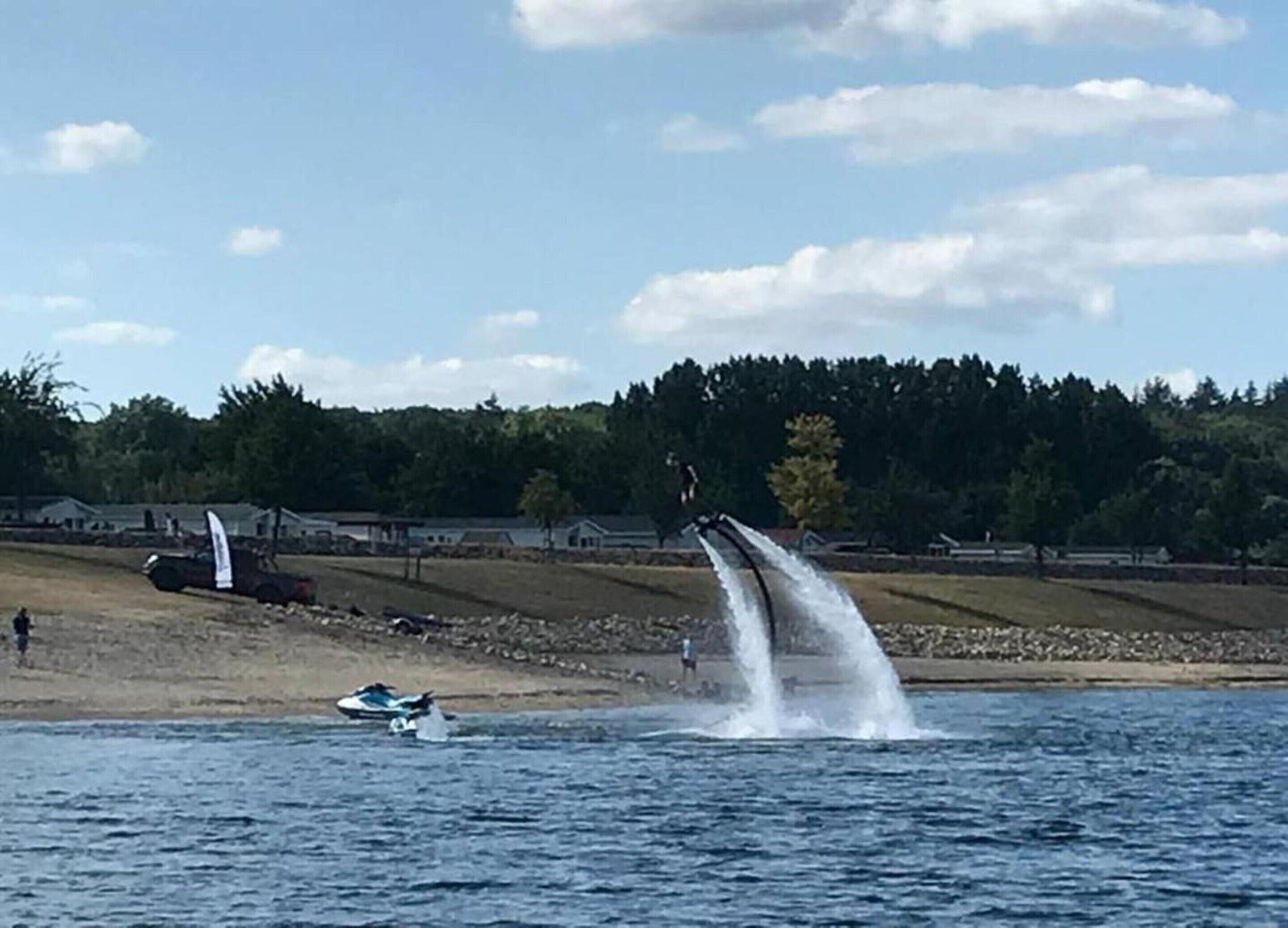 Watersportactiviteit waarbij iemand op een jetski rijdt en er waterstralen worden opgeworpen.