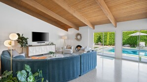 Ein modernes Wohnzimmer mit einem großen Ecksofa, einem Flachbildfernseher und einem Kamin.