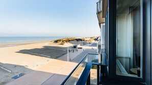 A modern building with a balcony overlooking a beach. - Apartment on Zeedijk With Stunning Sea View (Koksijde)