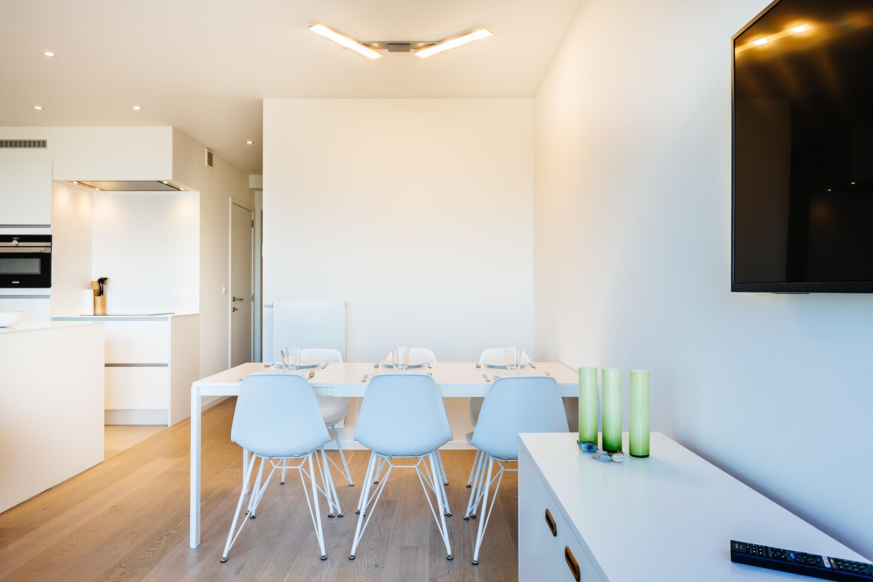 A modern kitchen with white cabinetry, a built-in oven, and a microwave.