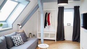 Una sala de estar moderna con un sofá gris, una mesita redonda y un tragaluz.