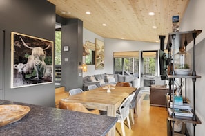 A modern kitchen with a wooden dining table, granite countertops, and a built-in bookshelf.