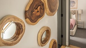A room with a wall decorated with wooden circular mirrors of varying sizes.
