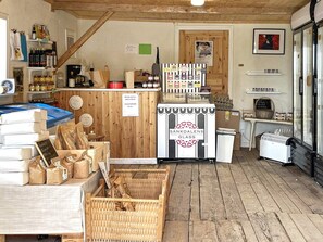 A rustic interior with wooden floors, a glass display case, and various packaged goods. - 5 Person Holiday Home in Valdemarsvik (Valdemarsvik)
