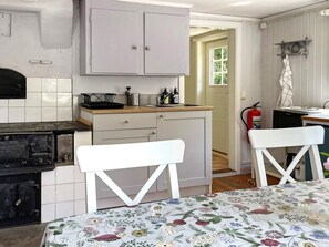 A kitchen with a stove, cabinets, and a window. - 5 Person Holiday Home in Valdemarsvik (Valdemarsvik)