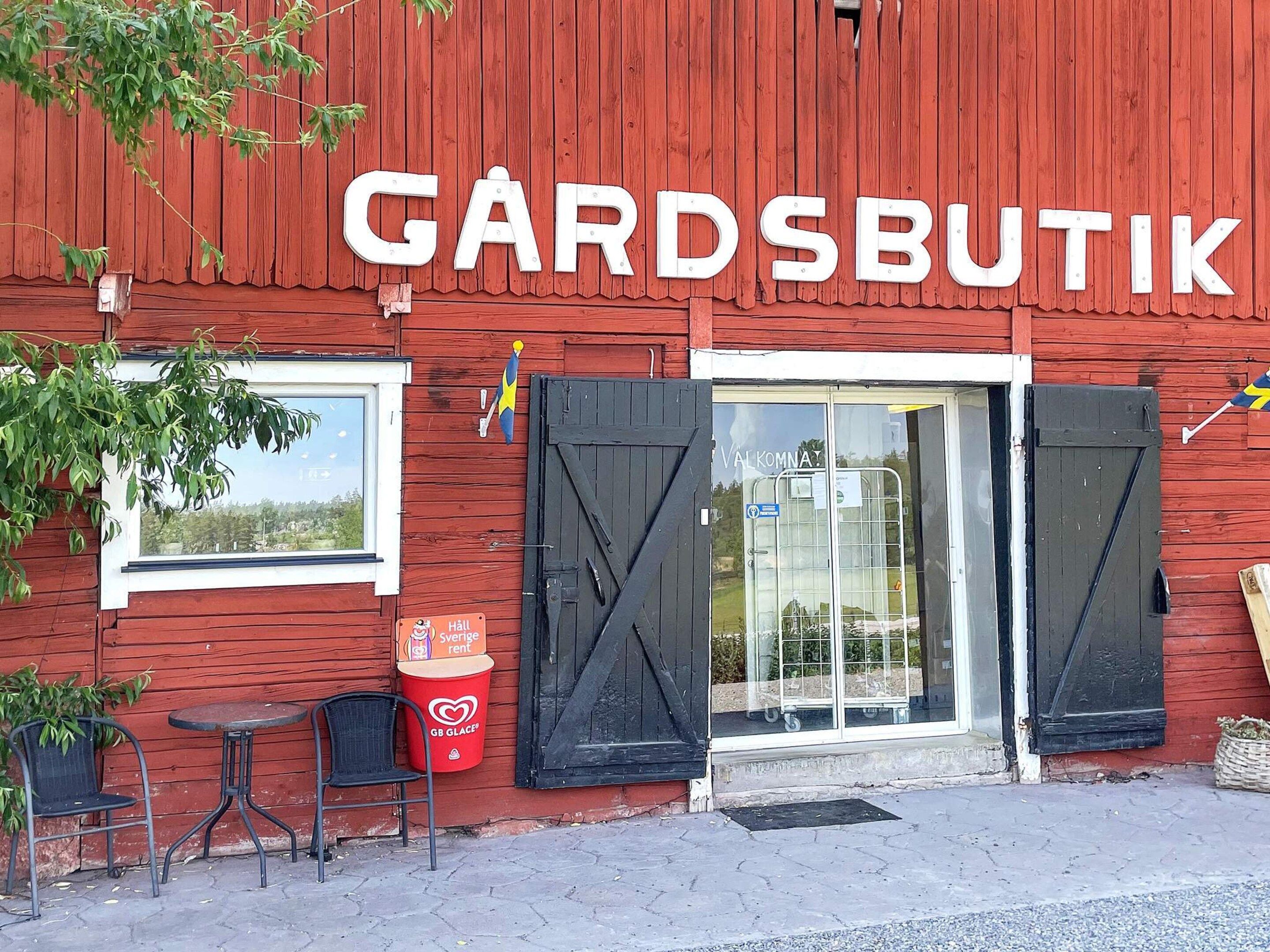 Een rood gebouw met het bord 'GARDSBUTIK' en een entree met zwarte luiken.