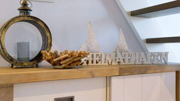 A wooden shelf with a mirror, a candle, and wooden sticks.