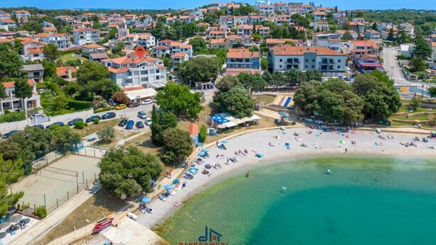 An aerial view of a coastal town with a beach, residential buildings, and a clear blue sky. - Donatella -apt 1- 10m van het Strand (Medulin)