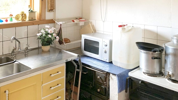 Una cocina equipada con microondas, un lavabo y una estufa.