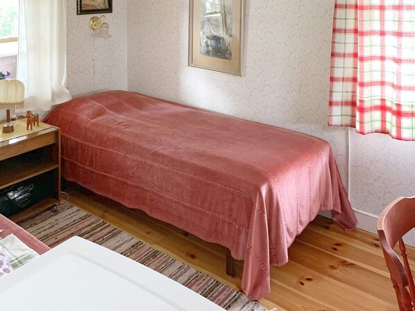 A bedroom with a single bed, a wooden desk, a chair, and a window with curtains. - 3 Person Holiday Home in Grangarde (Grangarde)