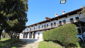 A white building with a balcony and a hanging lantern. - Belvilla by OYO Appartemento Chardonnay (Santa Giustina)