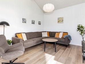 A modern living room with a grey sectional sofa, a round coffee table, and a black floor lamp. - 5 Star Holiday Home in Albaek (Aalbaek)