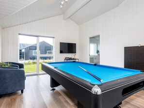 A pool table in a room with a large window, a television, and a door leading to a balcony. - 5 Star Holiday Home in Albaek (Aalbaek)