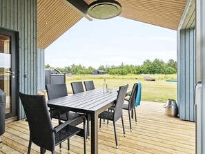 An outdoor dining area with a table and chairs, a wooden deck, and a view of the surrounding landscape. - 5 Star Holiday Home in Albaek (Aalbaek)