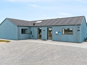 A blue building with a sloped roof, a door, and a window. - 5 Star Holiday Home in Albaek (Aalbaek)