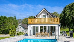 A house with a pool, a wooden deck, and a glass-enclosed patio. - 5 Star Holiday Home in Bastad (Bastad)