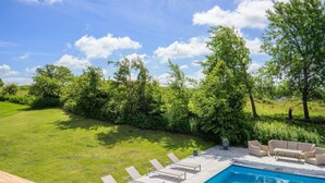 A swimming pool with lounge chairs and a wooden deck. - 5 Star Holiday Home in Bastad (Bastad)