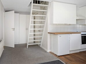 A kitchen with white cabinets, a wooden countertop, a built-in oven, and a white refrigerator. - 5 Star Holiday Home in Bastad (Bastad)