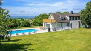 A house with a swimming pool, a covered patio, and a view of the landscape. - 5 Star Holiday Home in Bastad (Bastad)