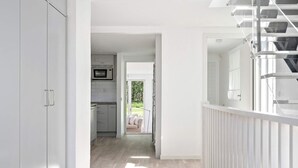 A modern interior with a kitchen, a staircase, and a view of the outdoors. - 5 Star Holiday Home in Bastad (Bastad)
