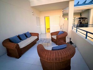 A balcony with wicker furniture, a white tiled floor, and a view of the interior through a door. - Belvilla by OYO Palacio de la Marina (Mojacar)
