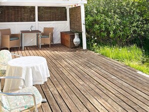 A wooden deck with outdoor furniture, including a table and chairs, and a decorative vase. - 6 Person Holiday Home in Knebel (Knebel)