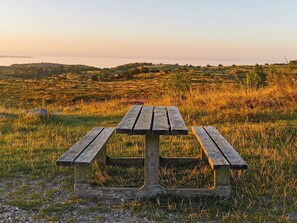 A wooden picnic table in a grassy field with a view of distant hills. - 6 Person Holiday Home in Knebel (Knebel)