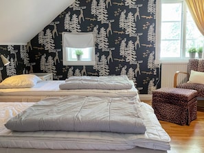 A bedroom with two beds, a window with a view, and a leopard print chair. - 5 Star Holiday Home in Odeshog (Odeshog)