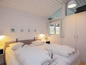 A bedroom with a bed, bedside tables, a window with curtains, and wall-mounted artwork. - 5 Person Holiday Park Home in Karrebaeksminde (Karrebæksminde)