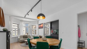 A modern living space with a dining area, kitchen, and seating area. - Renovated Apartment for Family (Blankenberge)