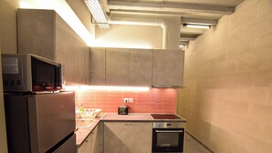 A compact kitchen with a refrigerator, microwave, oven, and a small countertop.