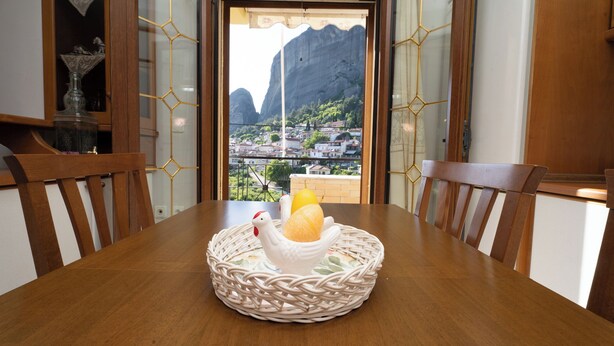 A dining table with a wicker centerpiece containing a white ceramic rooster and a yellow egg. - Romance Dream Meteora 1 (Kalampaka, Greece)