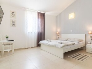 A modern bedroom with a bed, bedside tables, a chair, and a window with curtains. - Villa Martha Comfortable Holiday Residence (Zminj)