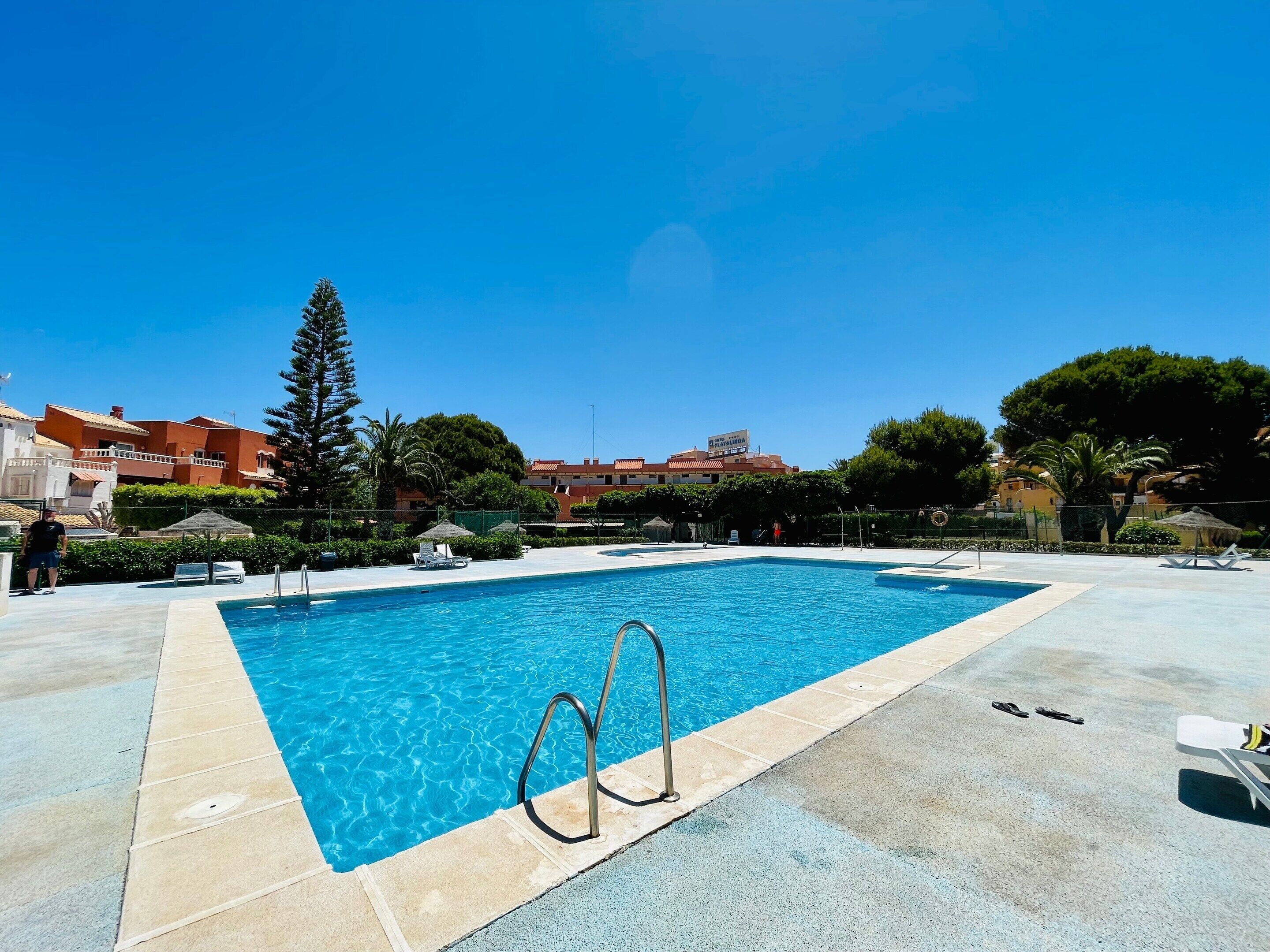 A rectangular swimming pool with a clear blue water surface, surrounded by a tiled deck.