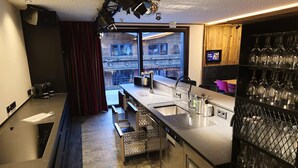 A modern kitchen with a large window, stainless steel appliances, and a wine rack. - Chalet in Zillertal Near Ski Slopes (Aschau Im Zillertal)