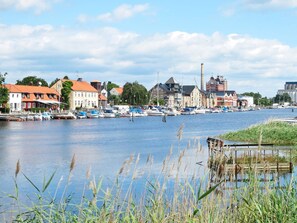 Un pueblo junto al río con edificios históricos, un puerto deportivo con barcos y un entorno de aguas tranquilas.
