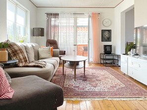 Un salon avec un canapé, une table basse et un téléviseur.
