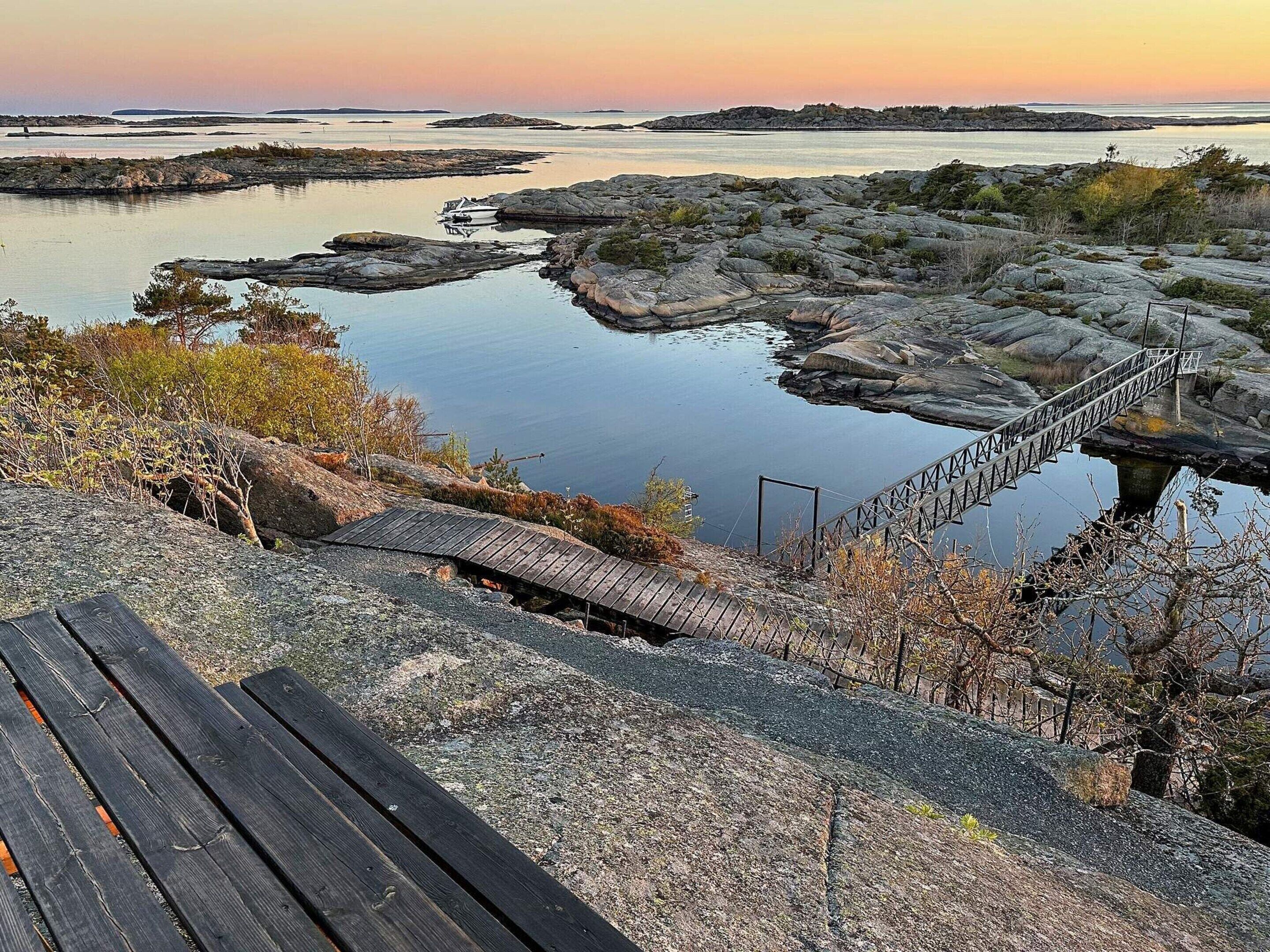A rocky landscape with a wooden bridge and a wooden bench.