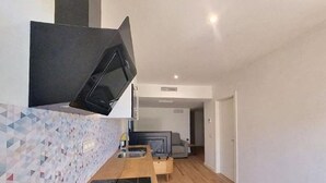 Una cocina moderna con microondas, pileta y encimera de madera.