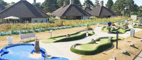 A landscaped garden with a pool, benches, and a pathway.