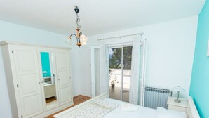 A bedroom with a bed, a wardrobe, a radiator, and a window. - Apartment Villa Rosea (Split)