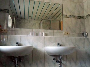 A bathroom with two sinks, a mirror, and a ceiling with a striped pattern.