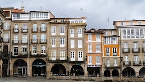 A row of multi-story buildings with commercial establishments on the ground floor, including a restaurant and a hotel. - Apartment in Ourense Near Hot Springs (Ourense)
