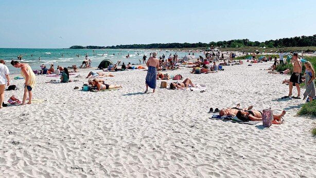 A crowded beach with people sunbathing and swimming. - 5 Person Holiday Home in Nexo (Nexø)