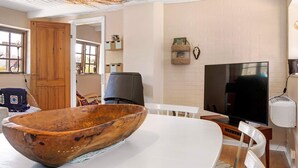 A modern living room with a large wooden bowl centerpiece, a flat-screen TV, and a rustic ceiling. - 5 Person Holiday Home in Nexo (Nexø)