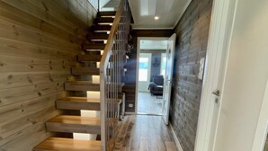 A wooden staircase leading to a modern interior with a view of a living area. - 4 Star Holiday Home in Mosterhamn-by Traum (Bomlo)